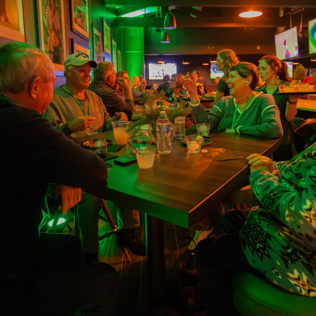 a group of people enjoying drinks and laughing around a table at the ParT Barn