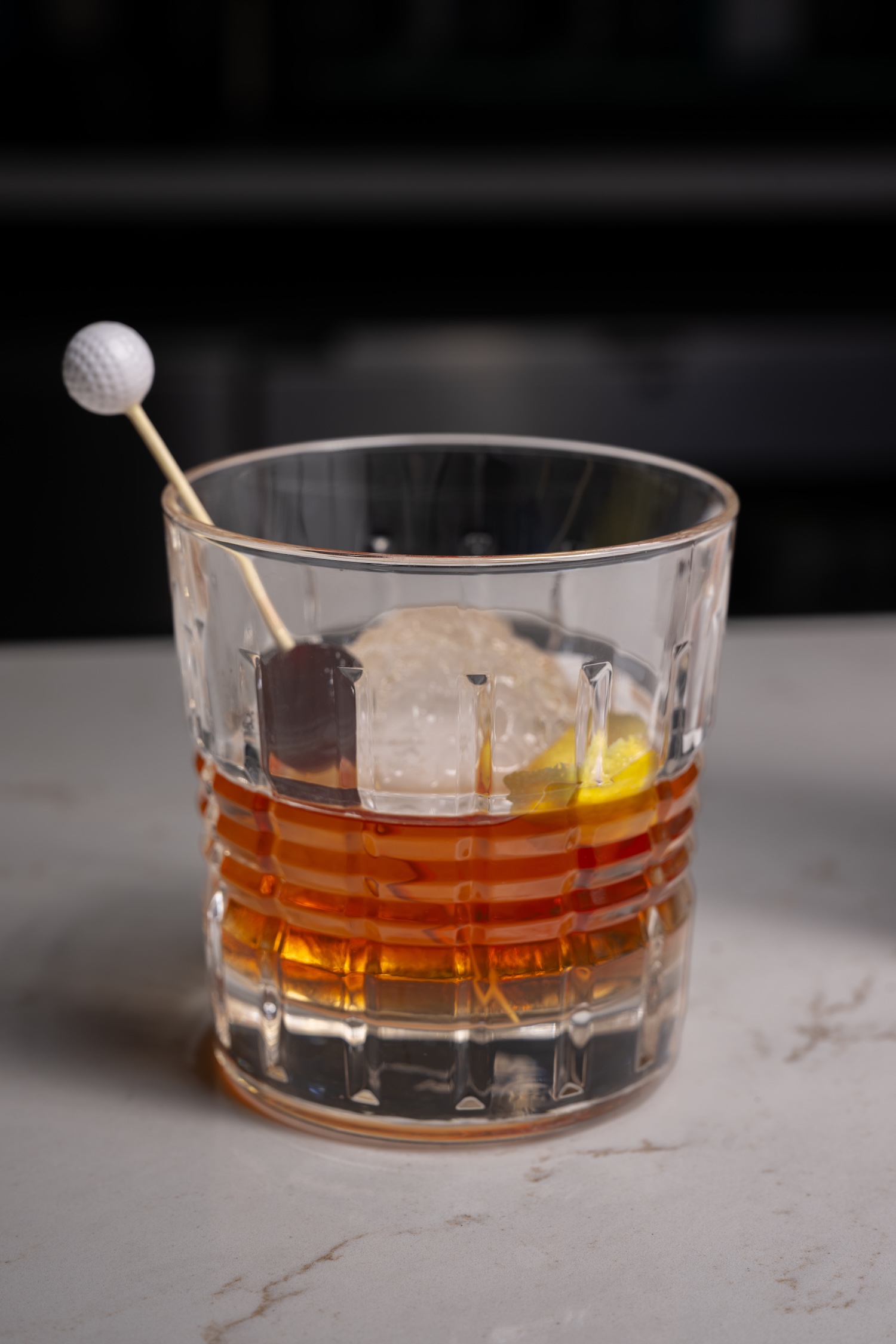 drink glass with alcohol and golf ball decoration on a toothpick