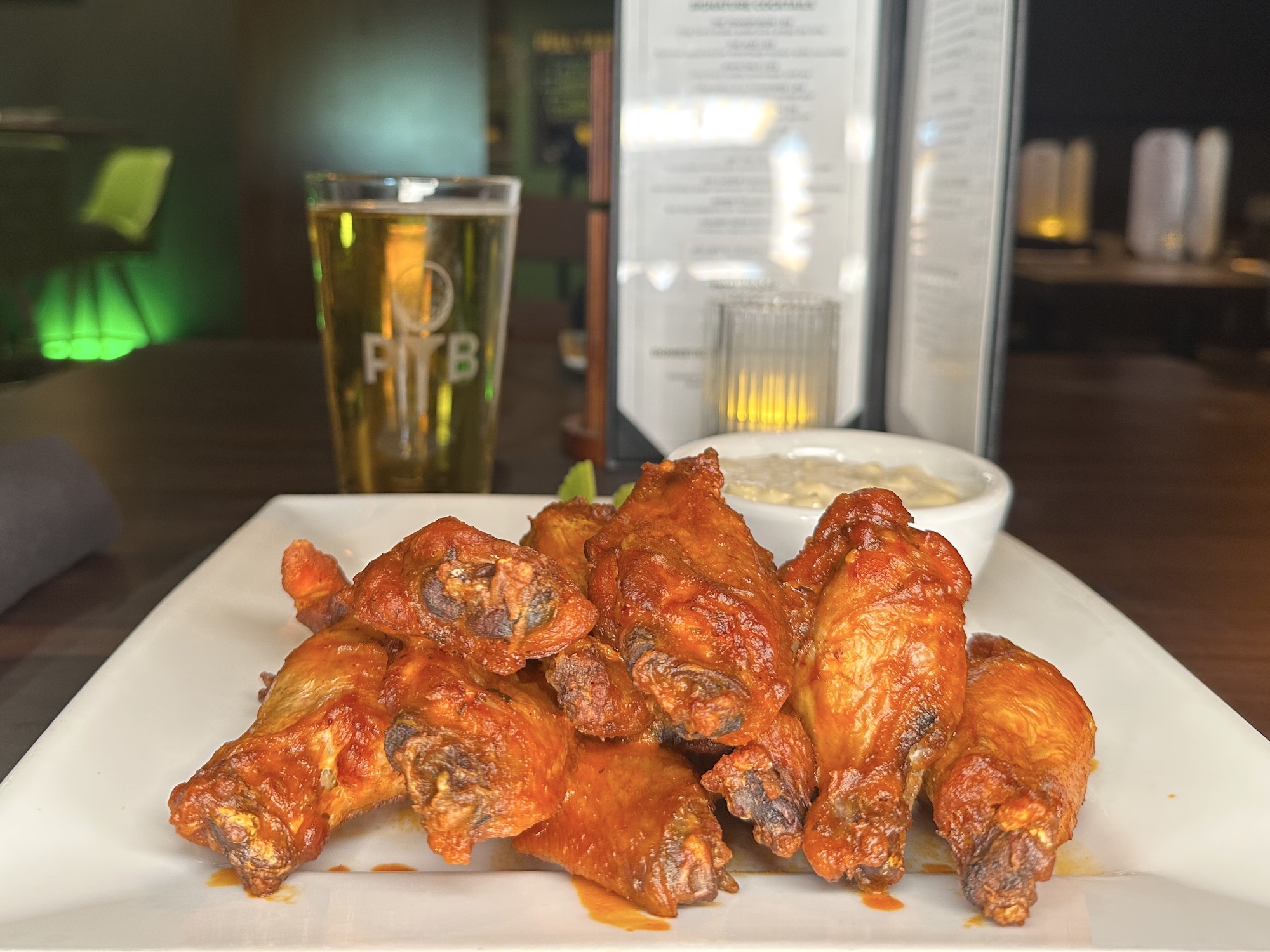 plate full of sauce covered wings with dipping sauce at the ParT Barn